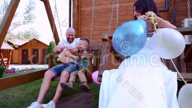 一家人坐着跷跷板，爸爸妈妈和宝宝节日快乐，爸爸妈妈手里拿着彩色气球，开心地笑着